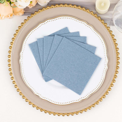 Blue linen napkins stacked on an elegant plate.