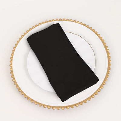 Black napkin elegantly placed on a decorative plate.