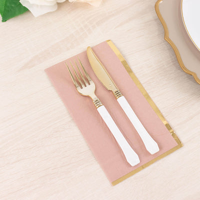 Gold-accented fork and knife on a pink napkin.