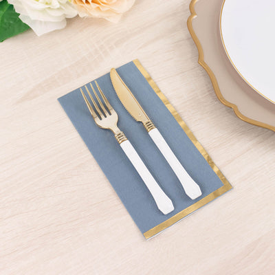 Elegant gold-accented cutlery on a blue napkin, styled for a table setting.