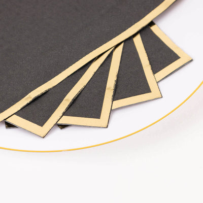 Black paper sheets with gold edges on a white background.