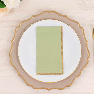 Green napkin with gold trim on an elegant dinner plate.