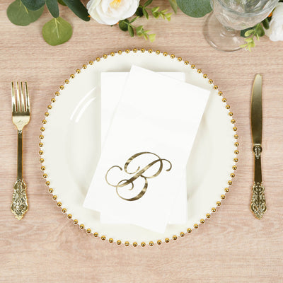 Elegant gold letter "B" napkin on a decorative plate setting.