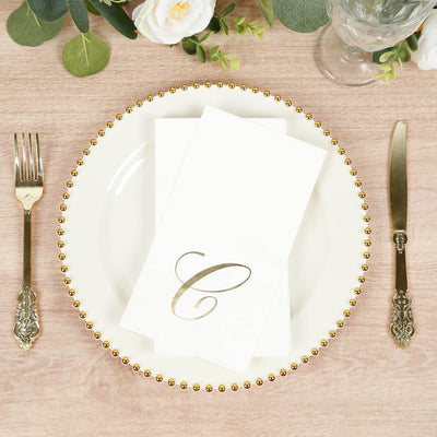 Elegant table setting with gold accents and monogrammed napkin.