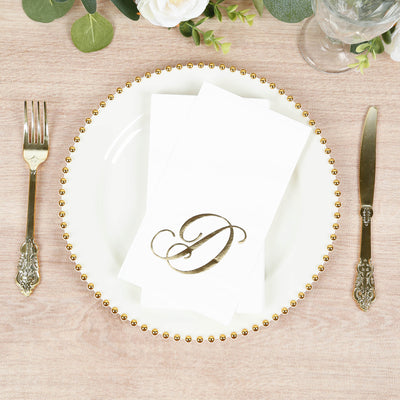 Elegant dining setup with a gold monogram napkin on a decorative plate.