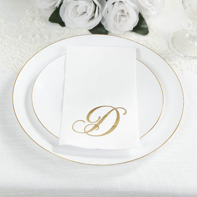 Elegant gold monogram napkin on a white plate, surrounded by decorative flowers.