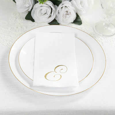 Elegant white plate with gold trim and a folded napkin featuring a gold monogram.