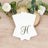 Elegant monogrammed stationery with a gold letter 'H' on a wooden surface.