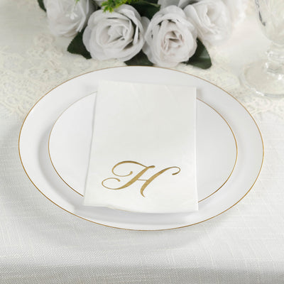 Elegant white plate with gold trim and monogrammed napkin.