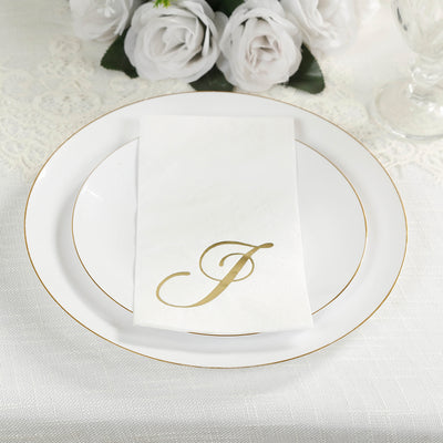 Elegant white plate set with gold rim and monogrammed napkin.