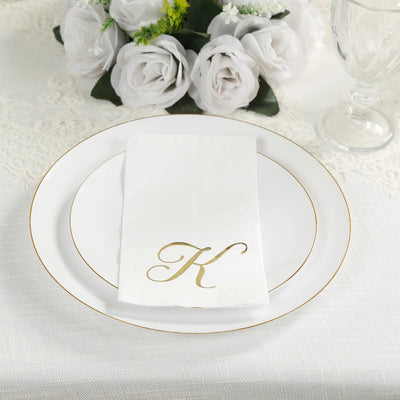 Elegant white plate setting with gold-accented napkin featuring a monogrammed "K".