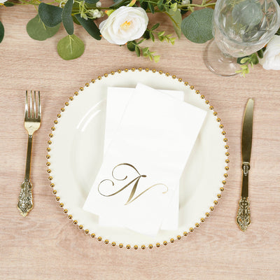 Elegant dinner setting with gold-accented plate and napkin featuring monogram "N".