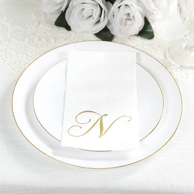 Elegant white plate with gold trim and monogrammed napkin.