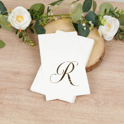 Personalized gold letter R stationery set on a wooden surface with flowers.