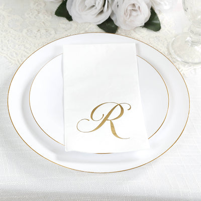 Elegant white plate with gold rim and personalized napkin featuring an "R" monogram.