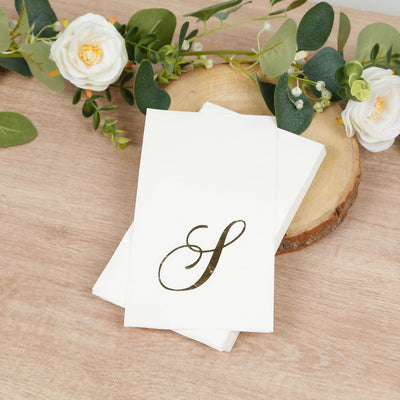 Elegant monogrammed napkins on a rustic wooden table with floral accents.