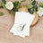 Elegant monogrammed napkins on a rustic wooden table with floral accents.
