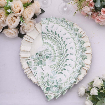 Decorative paper napkins with green foliage design on a plate.
