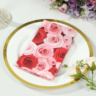 Pink rose-patterned napkin on a gold-rimmed plate with floral arrangement.