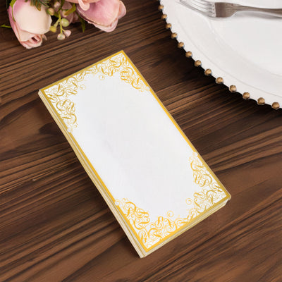 Elegant blank notepad with ornate gold border on wooden table.