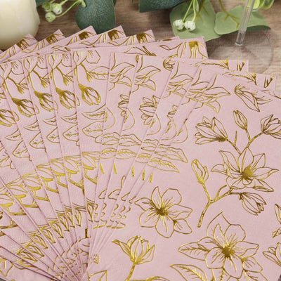 Pink floral napkins with gold foil detailing arranged in a fan shape.