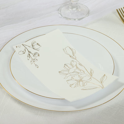 Elegant floral napkin on a white plate with gold trim.