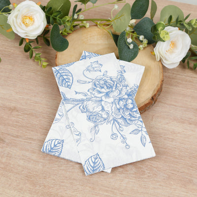 Floral-patterned napkins on a wooden surface with greenery and flowers.