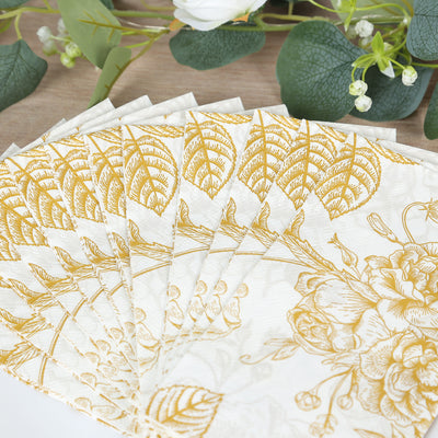 Gold floral napkins arranged in a fan shape on a wooden table.