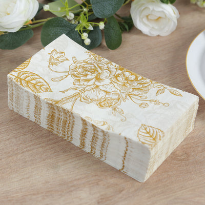 Elegant floral napkins with gold detailing, stacked on a wooden surface.