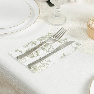 Floral-patterned napkin with fork and knife on elegant table setting.