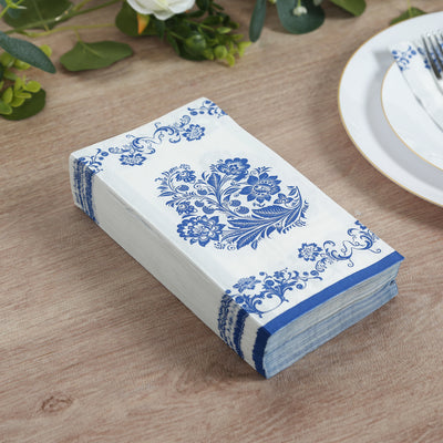 Blue floral patterned paper napkins stacked on a wooden table.