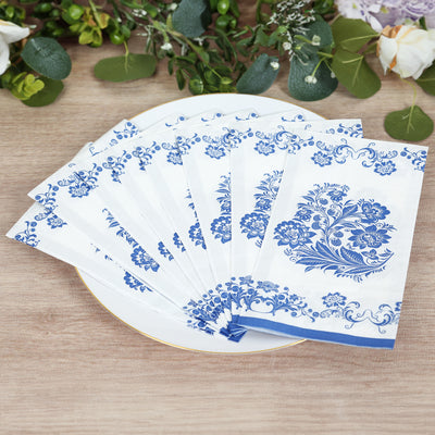 Blue floral patterned paper napkins stacked on a white plate.