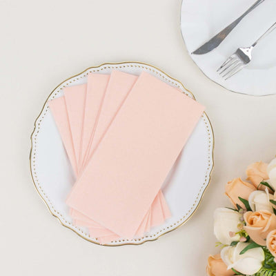 Pink paper napkins on an elegant plate with a floral arrangement.