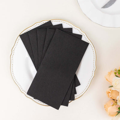 Black envelope set on an elegant white plate with floral accents.