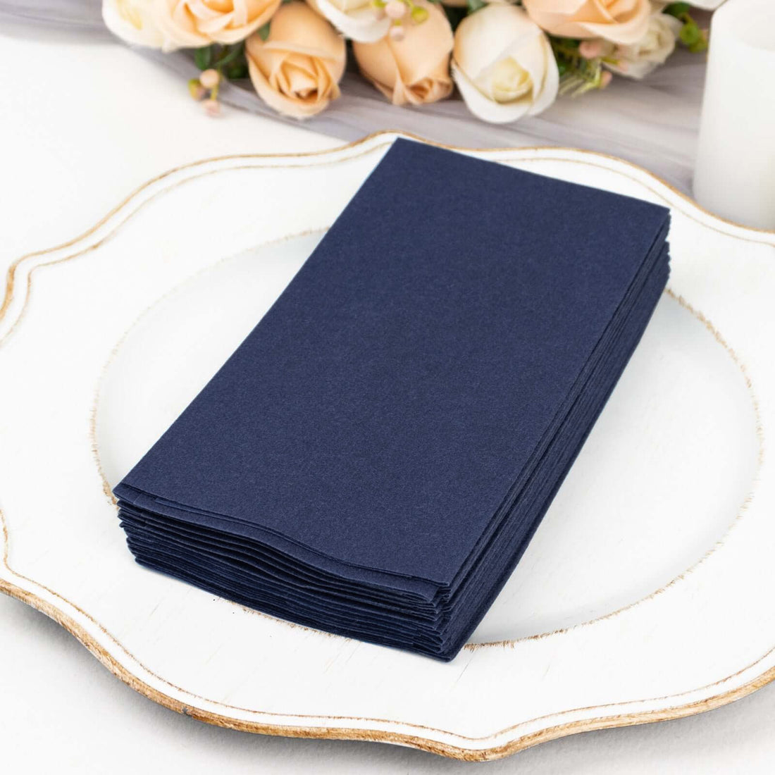 Navy blue cardstock stack on a decorative plate with flowers in the background.