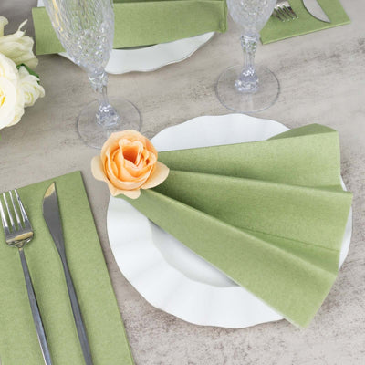 Elegant green napkin folded on a white plate, set for dining.