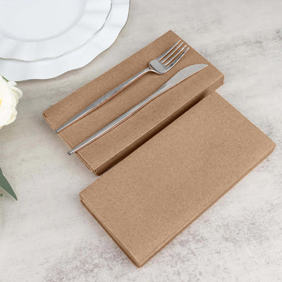 Brown kraft paper napkins with silver fork and knife on a table setting