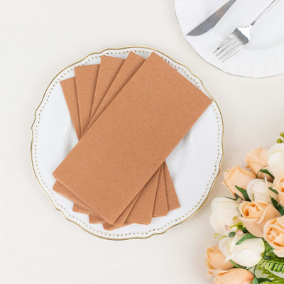 Brown kraft paper envelopes arranged on a decorative plate.
