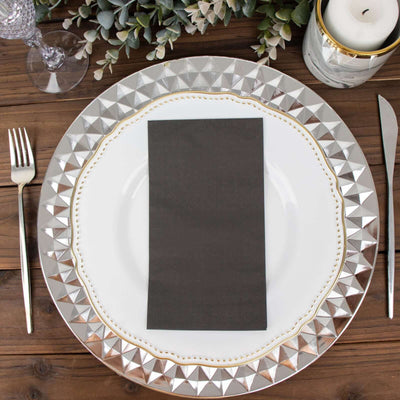 Elegant table setting with a decorative plate, napkin, fork, and knife.