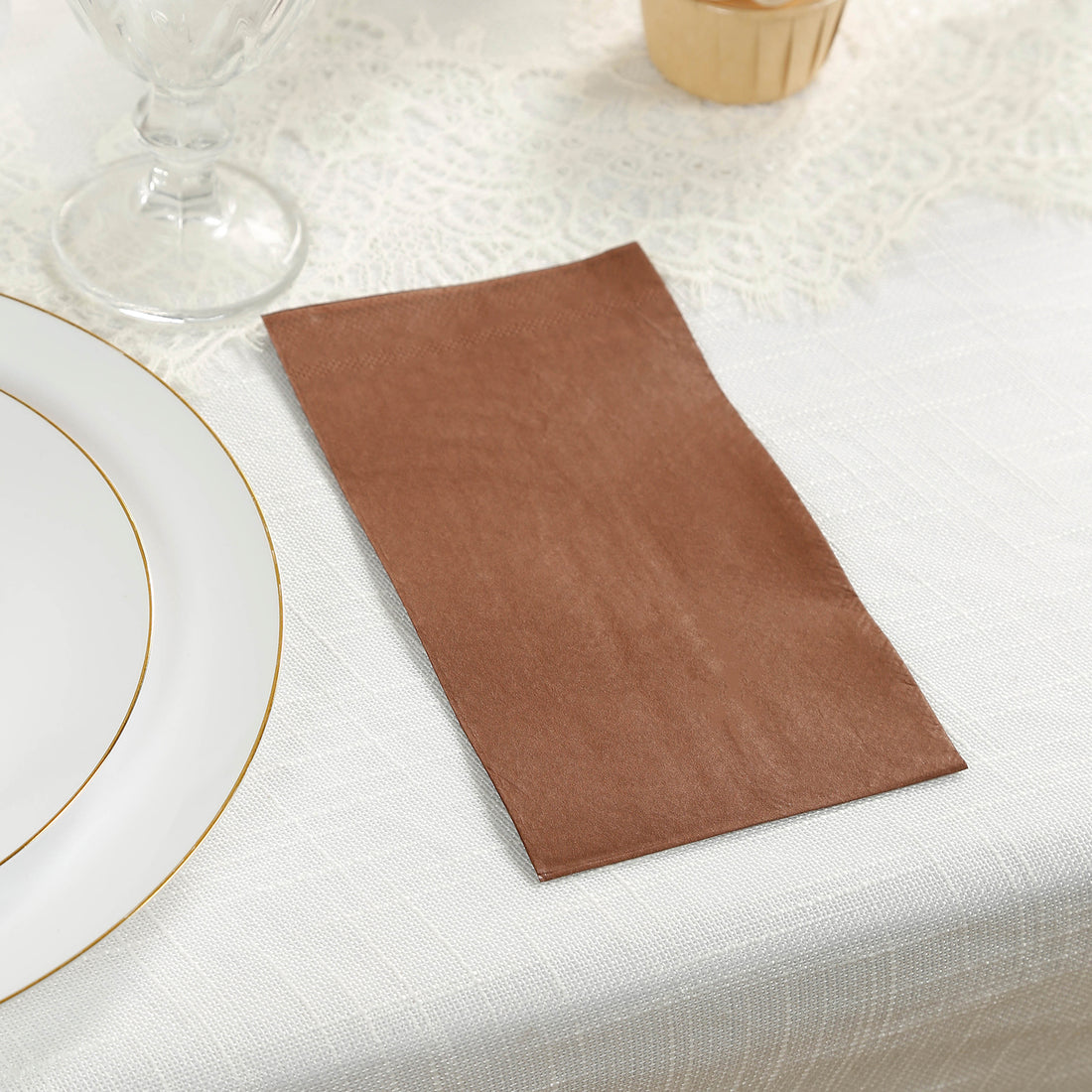 Brown paper napkin on a table setting with elegant dishware.