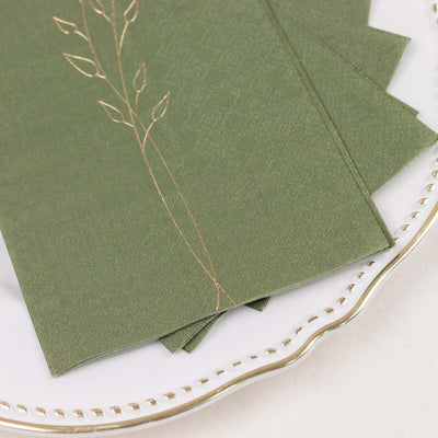 Elegant green stationery with gold leaf design on a decorative plate.