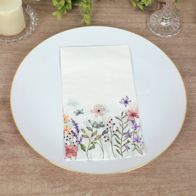 Floral paper napkin on a white plate with a wooden background.