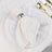 Elegant white napkin with gold dots and silver ring on a white plate setting