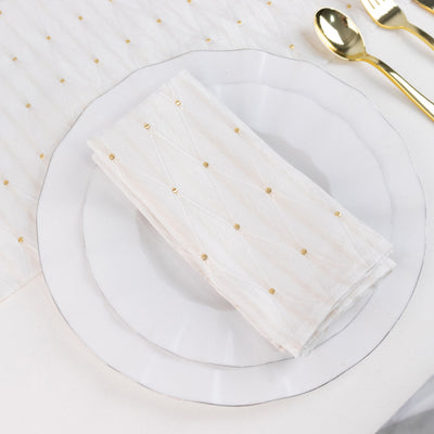 Elegant white plate with gold-dotted napkin and gold spoons on table setting