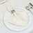Elegant cream napkin with silver napkin ring on white gold-rimmed table setting