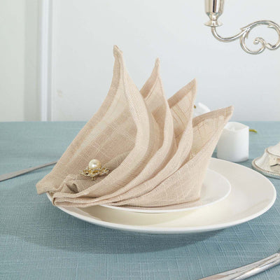 Elegant beige napkins elegantly folded on a white plate.