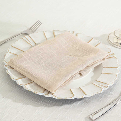 Beige linen napkin on a decorative plate with cutlery.