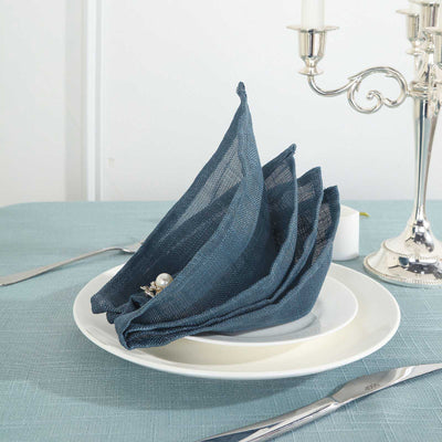 Elegant navy blue linen napkins arranged on a white plate setting.