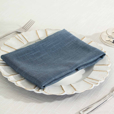 Blue textured napkin on a decorative plate setting.