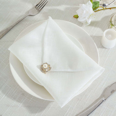 Elegant white napkin with pearl brooch on a plate